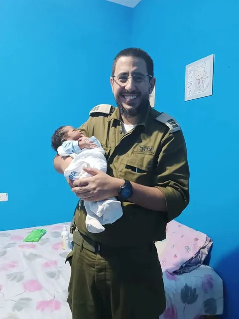 איתמר חמו במדי צה״ל, מחזיק תינוק אחרי ברית